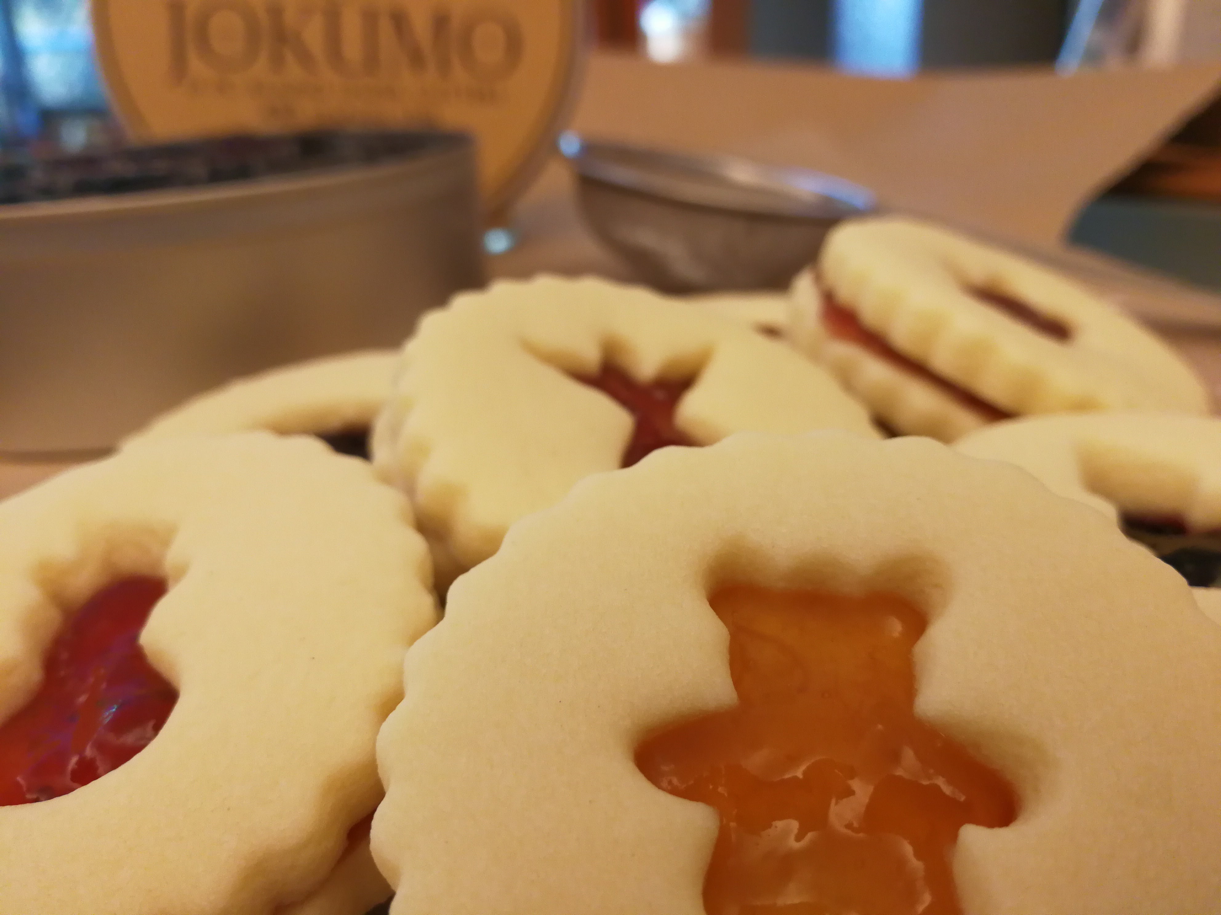 Cookies with jelly filling on a tray, with a blurred background